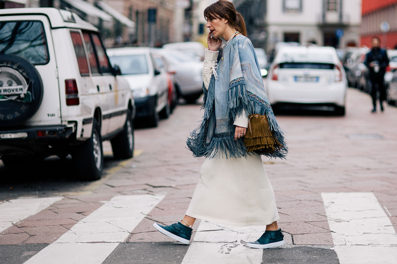 Aurora Sansone wearing a long skirt, a fringed poncho and fringed bag in Milan, Italy