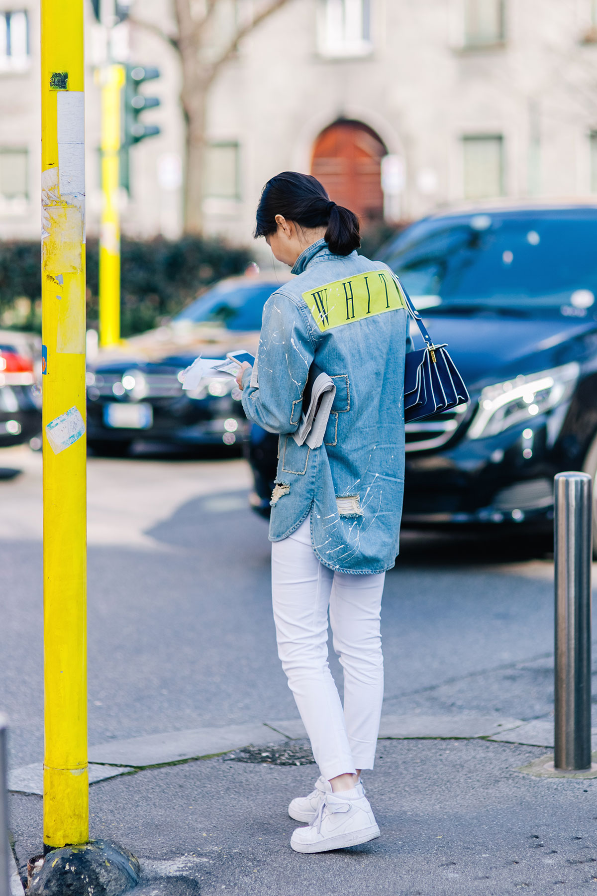 Woman wearing an Off-White denim shirt, white jeans and Nike shoes after the Marni Fall/Winter 2015-2016 fashion show in Milan, Italy