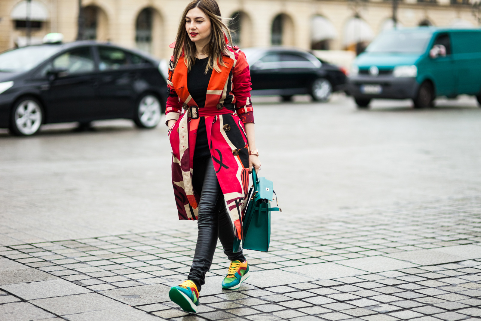 Nasiba Adilova wearing a printed trench coat and sneakers by Burberry Prorsum and a Hermes bag before the Schiaparelli Spring 2015 Haute Couture Fashion show in Paris, France