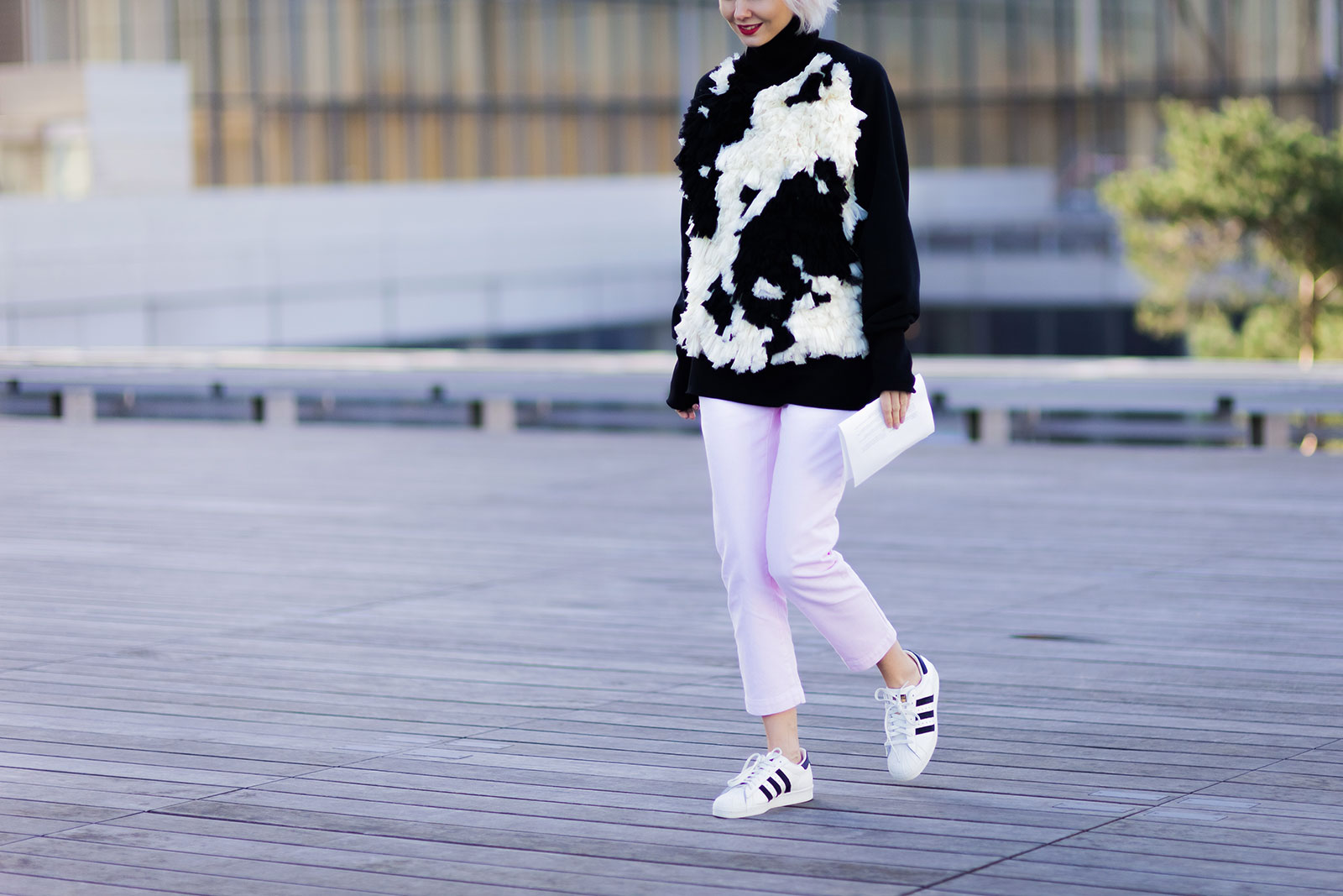 Olga Karput wearing a Nina Donis sweater, pink pants and Adidas superstar sneakers after the Christophe Lemaire Fall 2015 fashion show in Paris, France