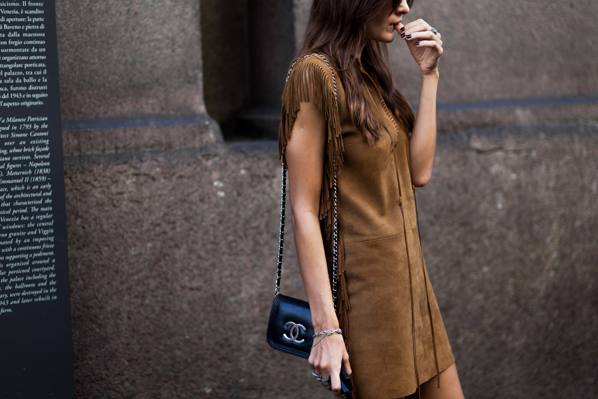 Woman wearing leather mini dress and Chanel mini bag before a fashion show