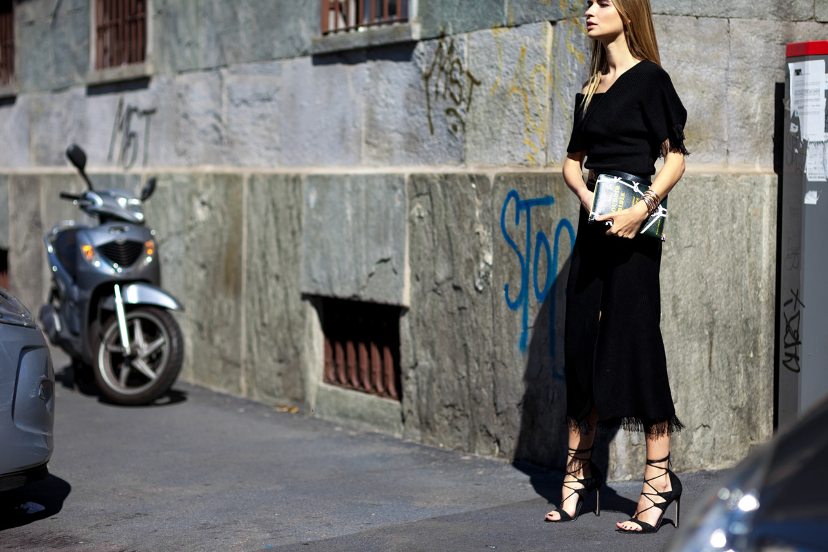Russian blogger Maria Kolosova wearing black midi dress and lace-up heels after a fashion show in Milan