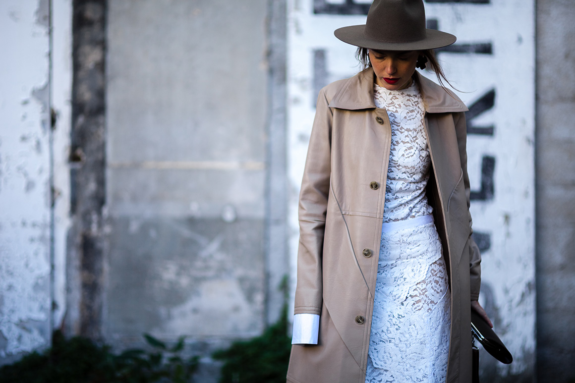 Lilia Litkovskaya wearing a white lace dress, trench coat and hat after a show in Paris, France