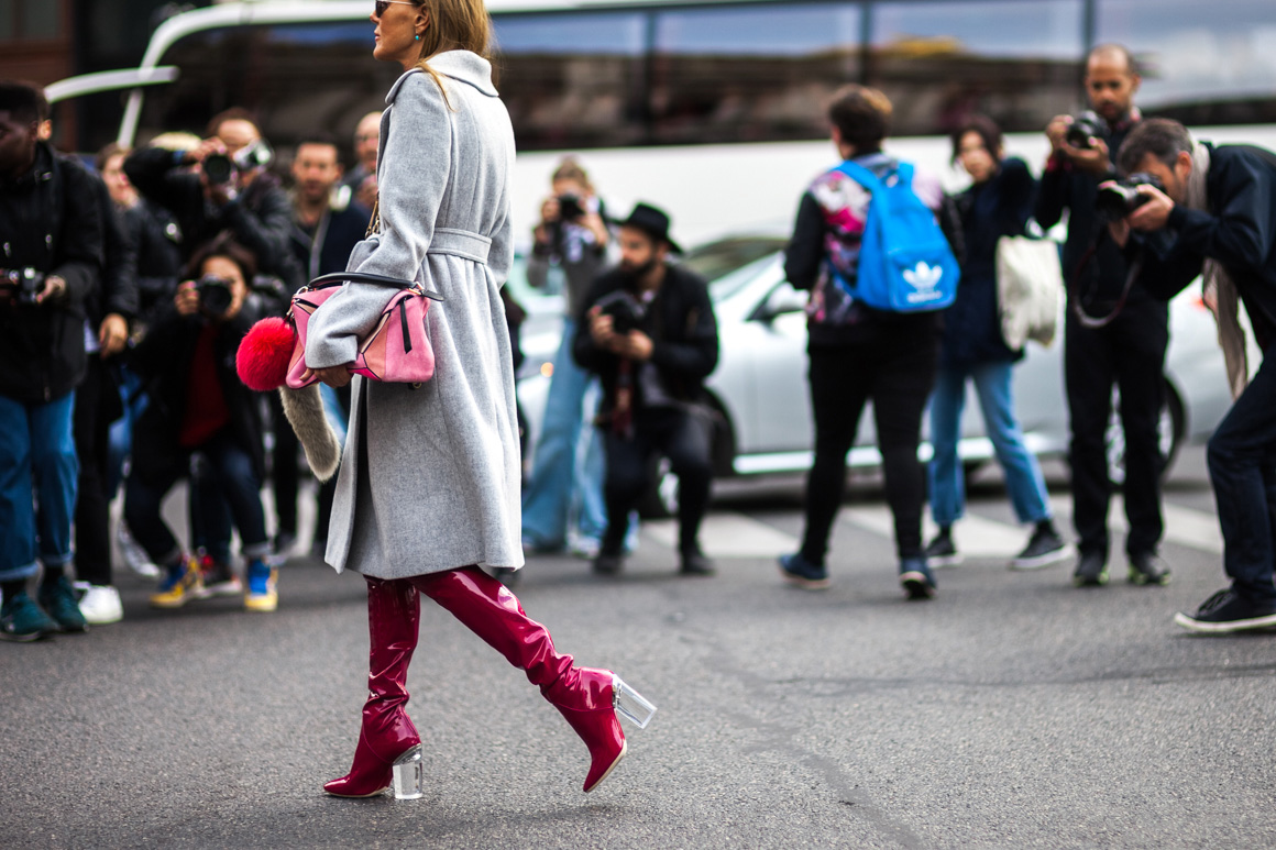 Anna Dello Russo wearing a grey coat and Dior vinyl boots before a show in Paris, France