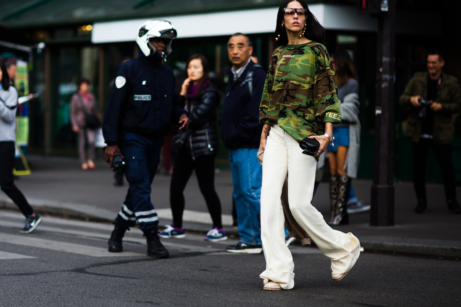 Gilda Ambrosio wearing a Yeezy camouflage t-shirt and white pants after the Stella McCartney fashion show in Paris, France