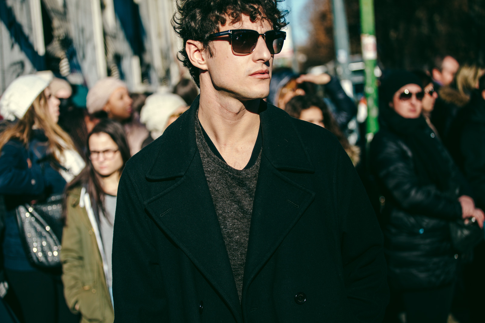 Giovanni Dario Laudicina wearing a black coat and sunglasses before the Calvin Klein Men's Fashion show