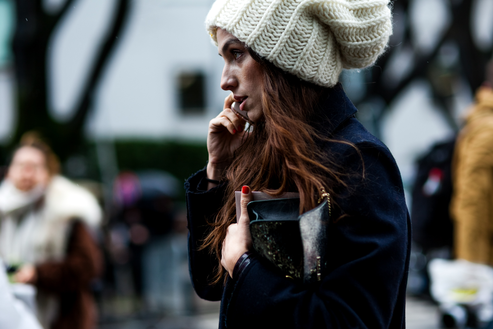 Erika Boldrin wearing a navy coat and white beanie hat before the Armani fashion show in Milan, Italy
