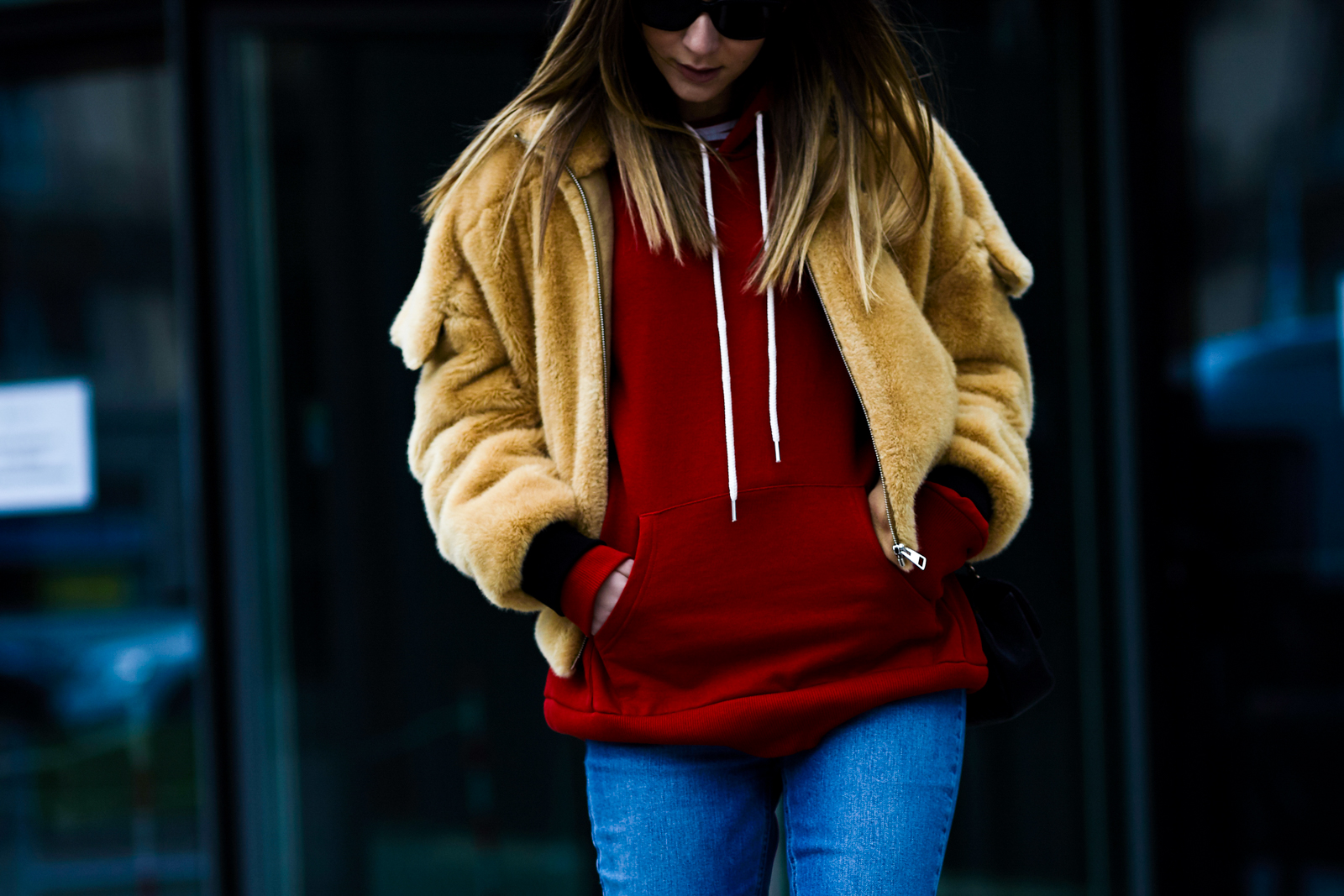 MFW Street Style: Italian blogger Chiara Capitani wearing a J.w.anderson Beige Teddy Flight Jacket and red hoodie after a fashion show in Milan, Italy