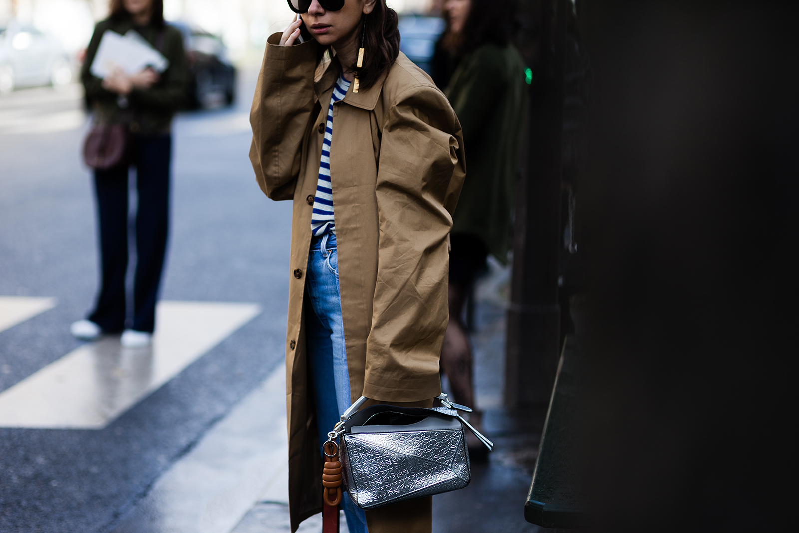 Natasha Goldenberg wearing a trench coat, Vetements jeans and Loewe bag before a fashion show in Paris, France