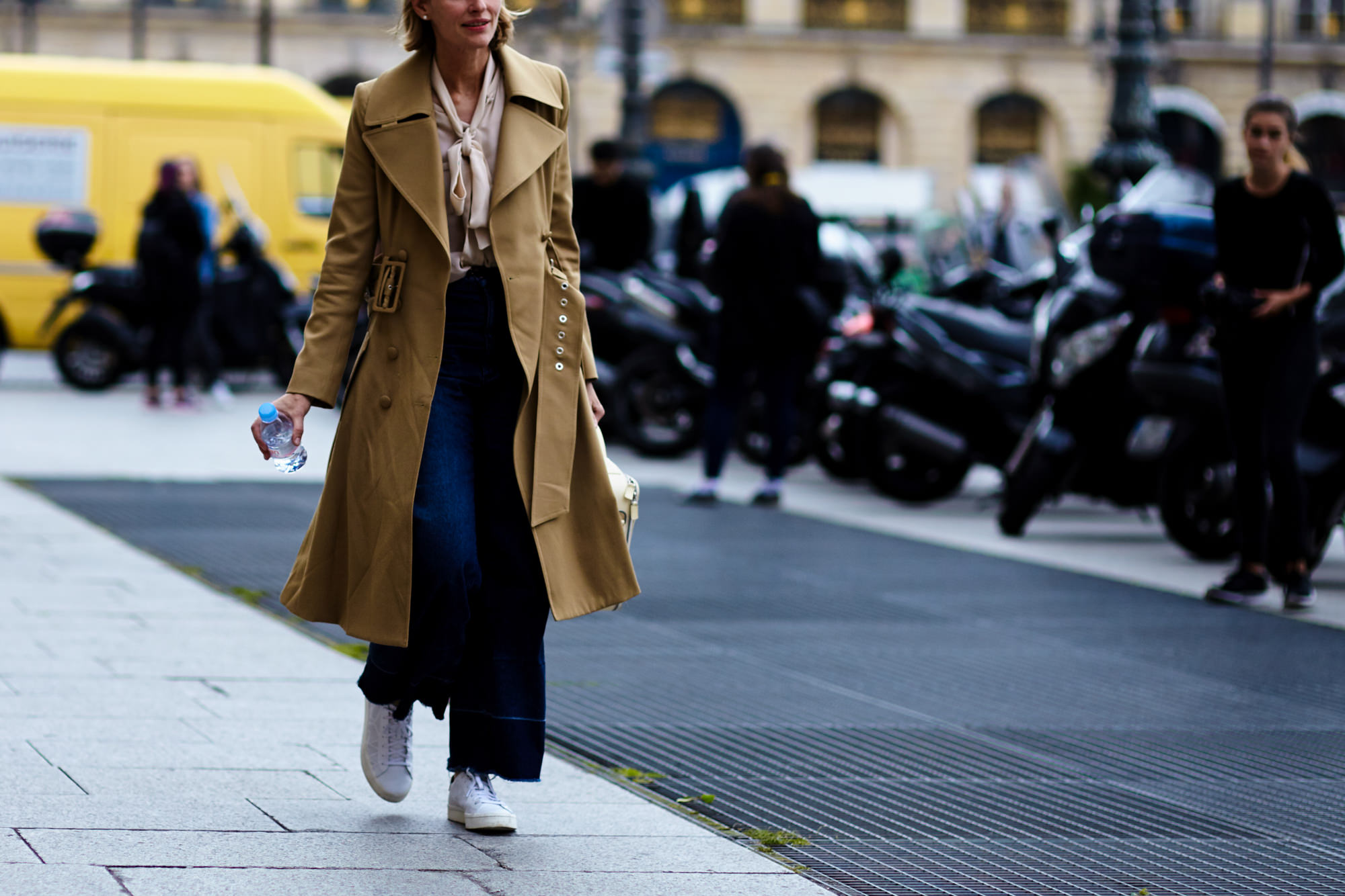 Paris Haute Couture Street Style: A woman wearing jeans and a trench coat after a fashion show in Paris, France