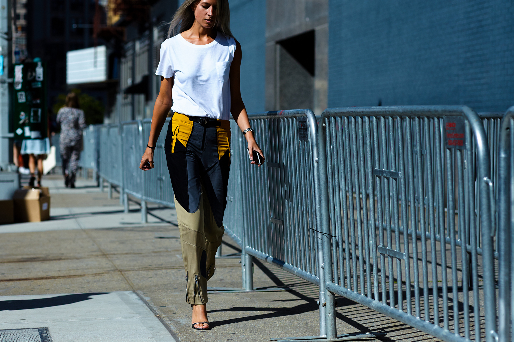 NYFW Spring-Summer 2017 Streetstyle: Sarah Harris wearing a white tee and Louis Vuitton color block pants and silver sandals after a show in New York City
