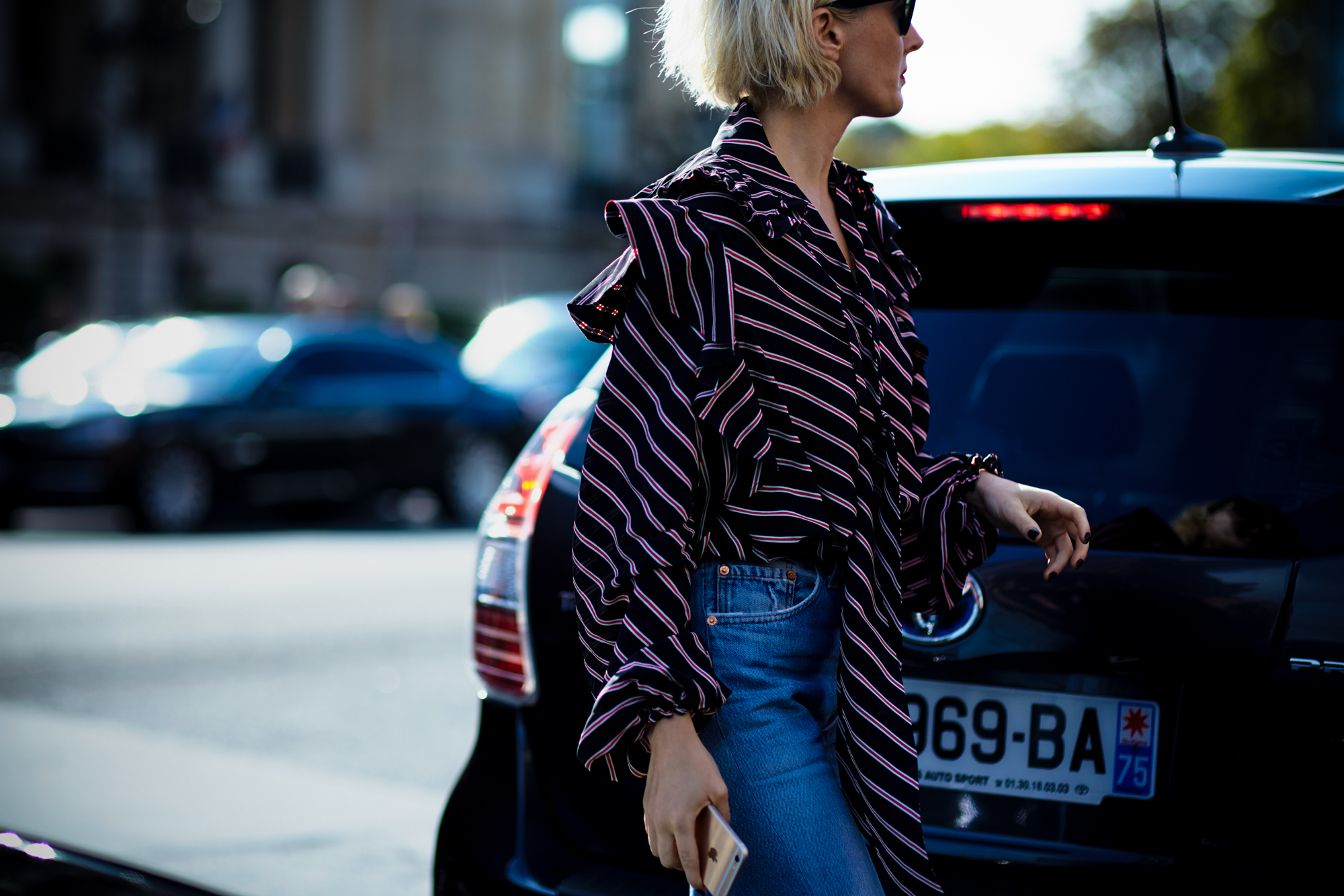 PFW Spring-Summer 2017 Street Style: A woman wearing a ruffle blouse and jeans before a fashion show in Paris, France