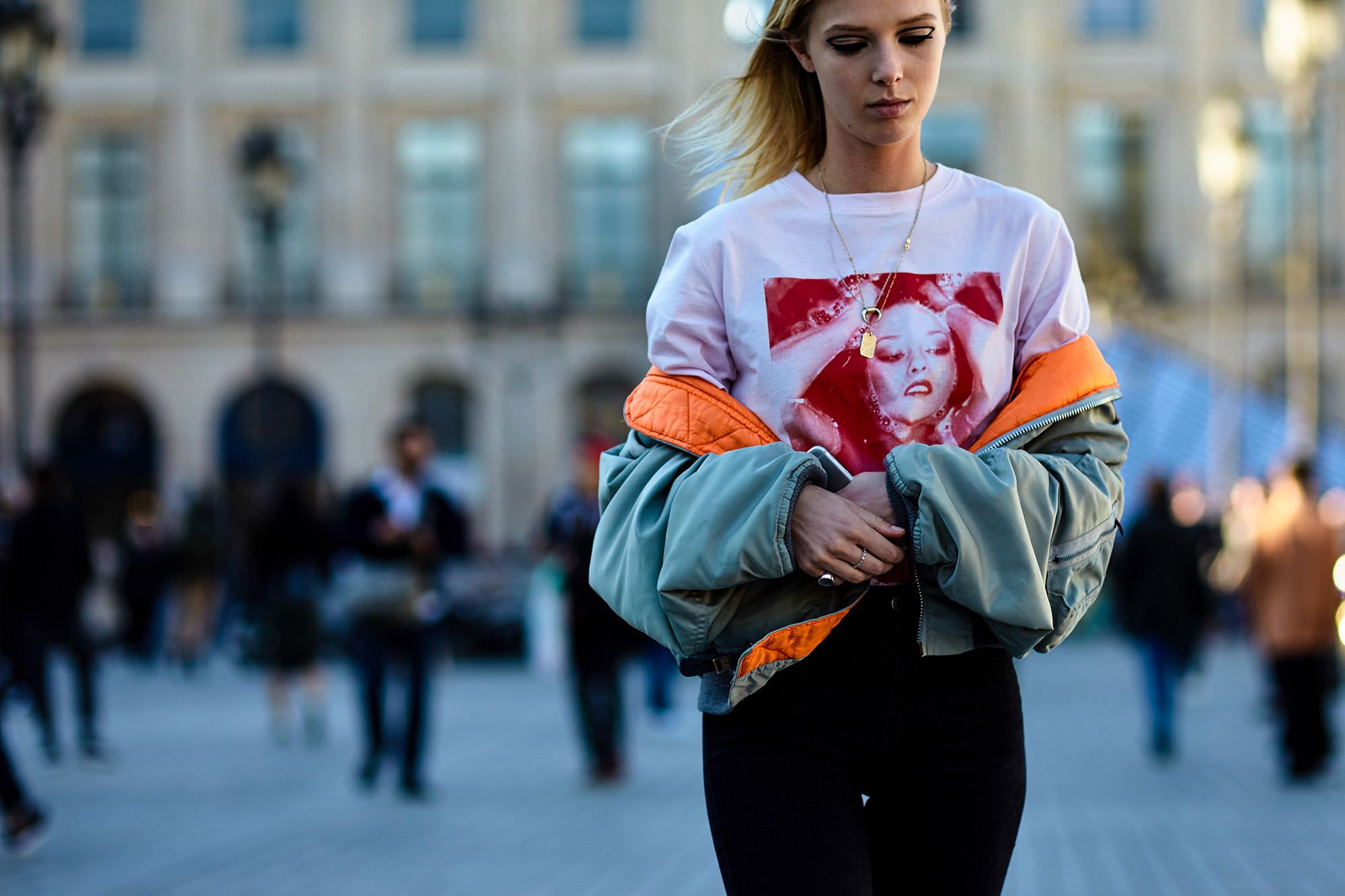PFW Spring-Summer 2017 street style: Model Ulrikke Hoeyer wearing a graphic tee and a green bomber jacket after the Louis Vuitton Spring 2017 fashion show