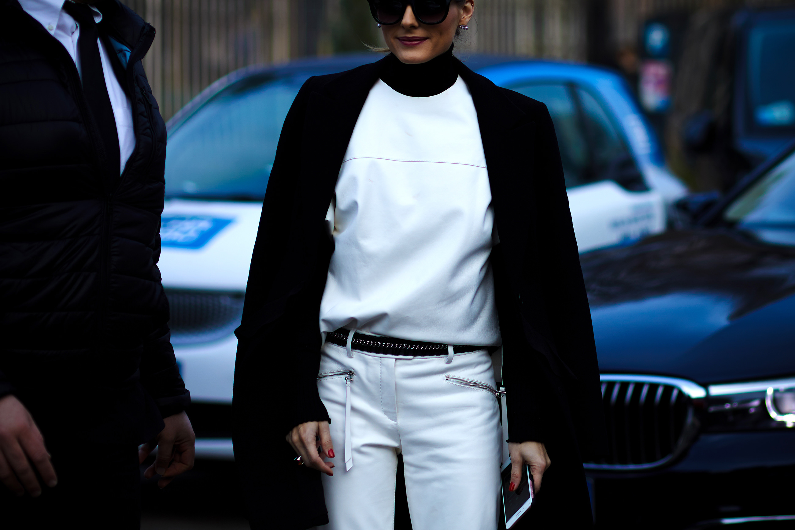 Olivia Palermo wearing white leather pants and top and black coat after a fashion show in Milan, Italy