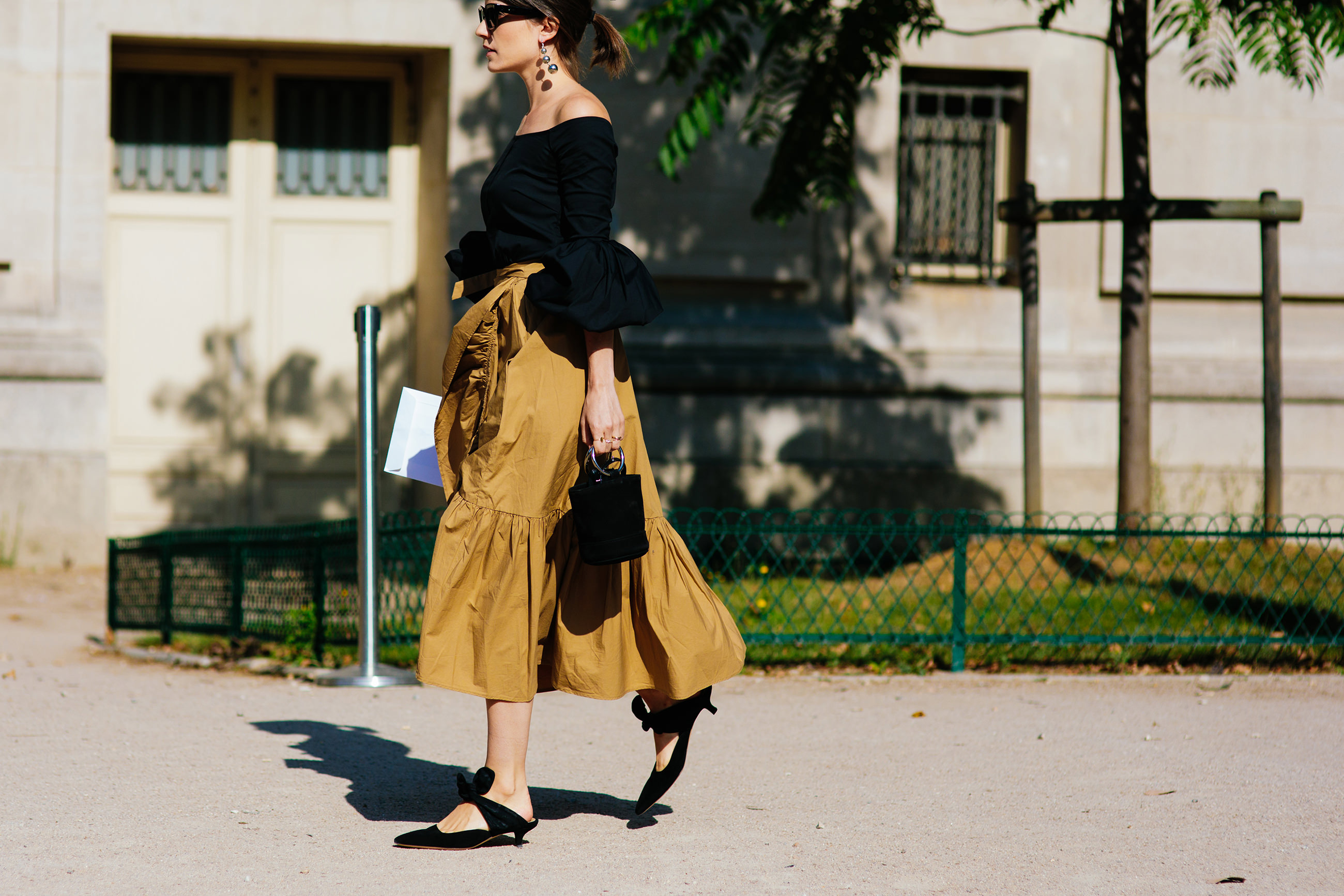 Blogger Carola Pojer wearing a black top and brown ruffled skirt before Chanel Haute Couture fashion show in Paris, France