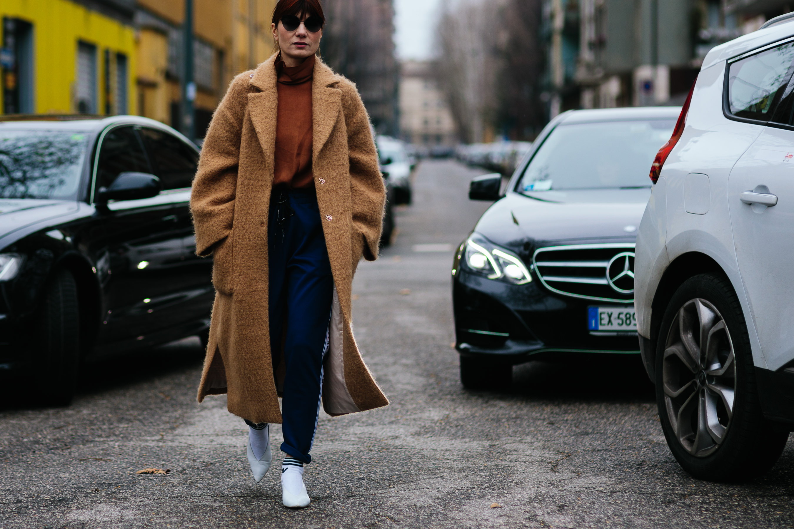 Italian woman wearing camel coat and white pumps